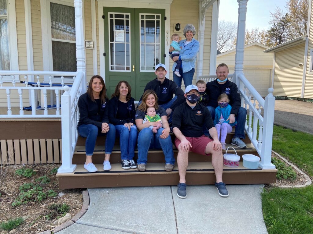 OCB colleagues sitting on front porch of house