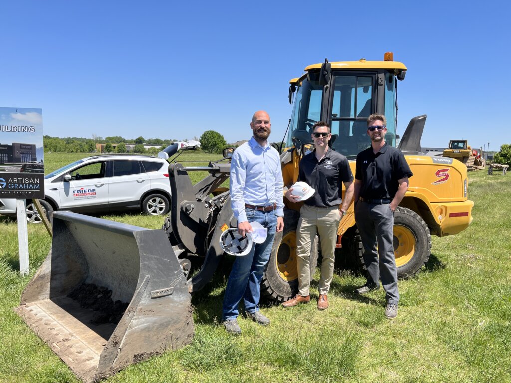 Matt Krogman, Dan Carey and Aaron Anderson next to bulldozer